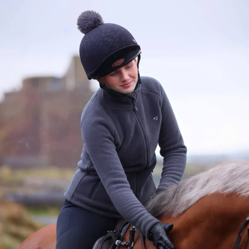 Woman smiling in Aubrion Restore Full Zip Fleece Charcoal with black leggings and thermal sneakers.