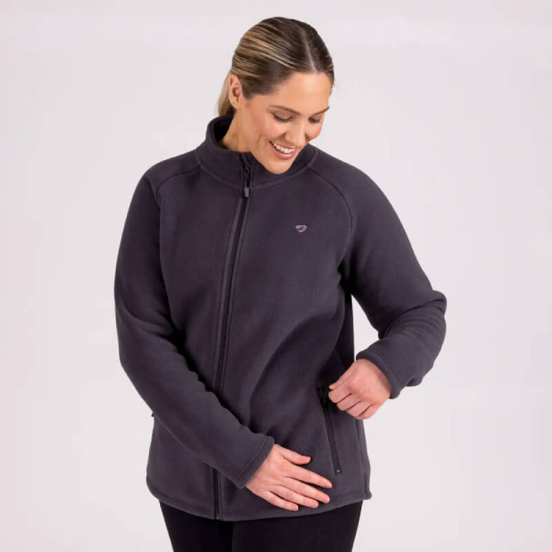 Woman smiling and unzipping the Aubrion Restore Full Zip Fleece Charcoal jacket’s side pocket.