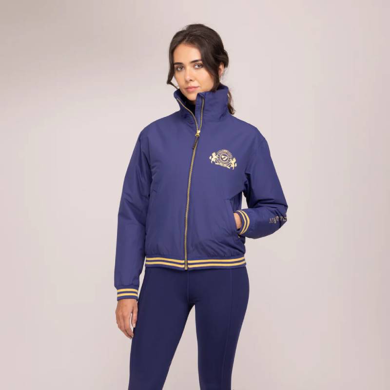 Woman in Aubrion Team Blouson Midnight jacket and pants stands against a light background.