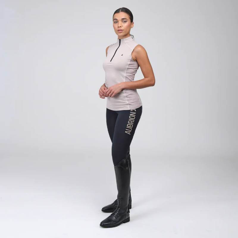 Woman in Aubrion React Rhythm Riding Tights Shadow and a sleeveless top, posing in a studio.