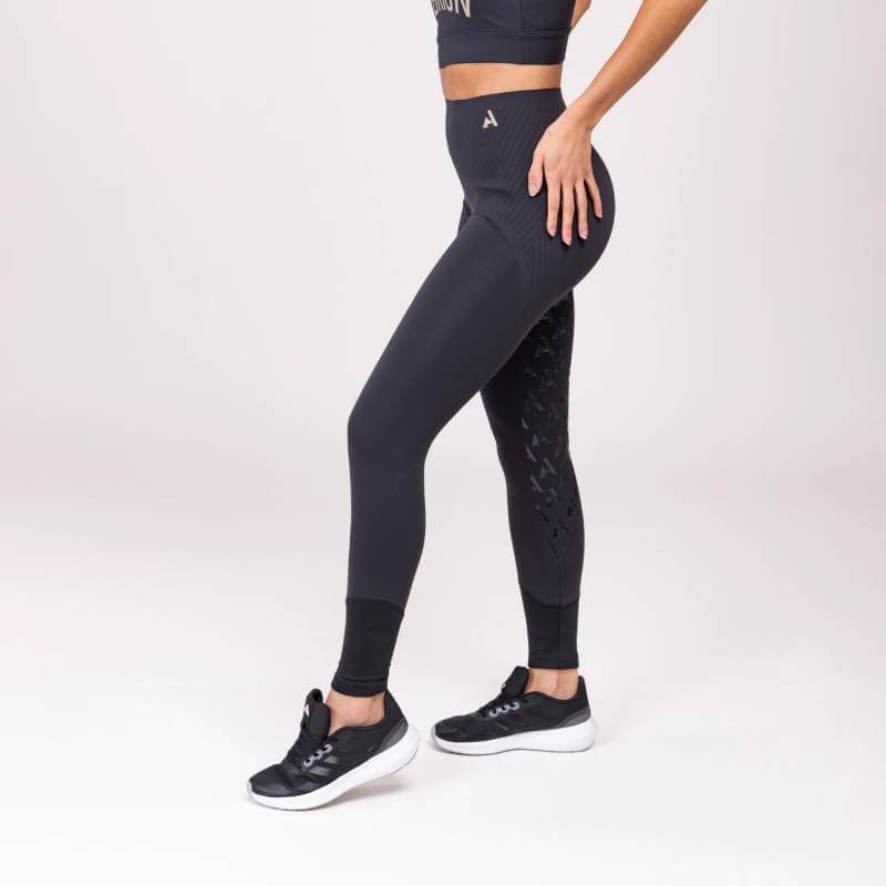 Woman in Aubrion React Sculpt Riding Tights Shadow posing against a plain white background.