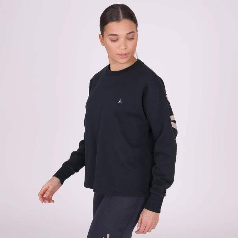 Woman in a Shires Aubrion React Sweatshirt Shadow poses against a plain light background.