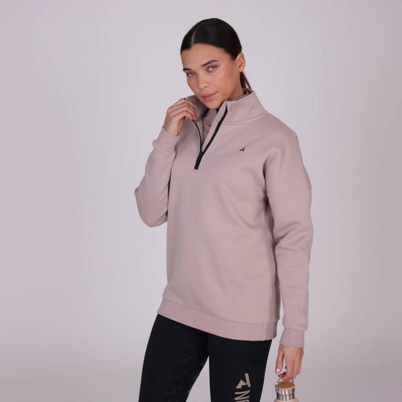 Woman in a Shires Aubrion React Half Zip Sweatshirt Sand and black leggings holding a water bottle.