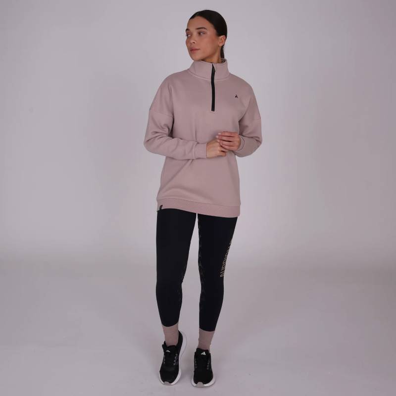 Woman in an Aubrion React Half Zip Sweatshirt Sand by Shires stands against a light background.