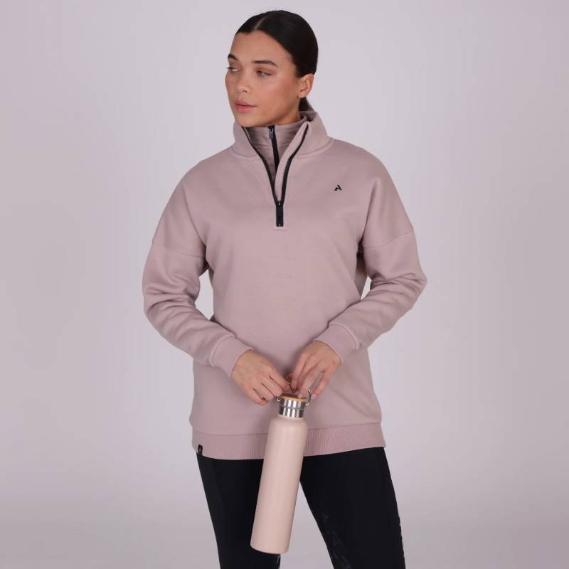 Woman in a Shires Aubrion React Half Zip Sweatshirt Sand holds a matching water bottle.