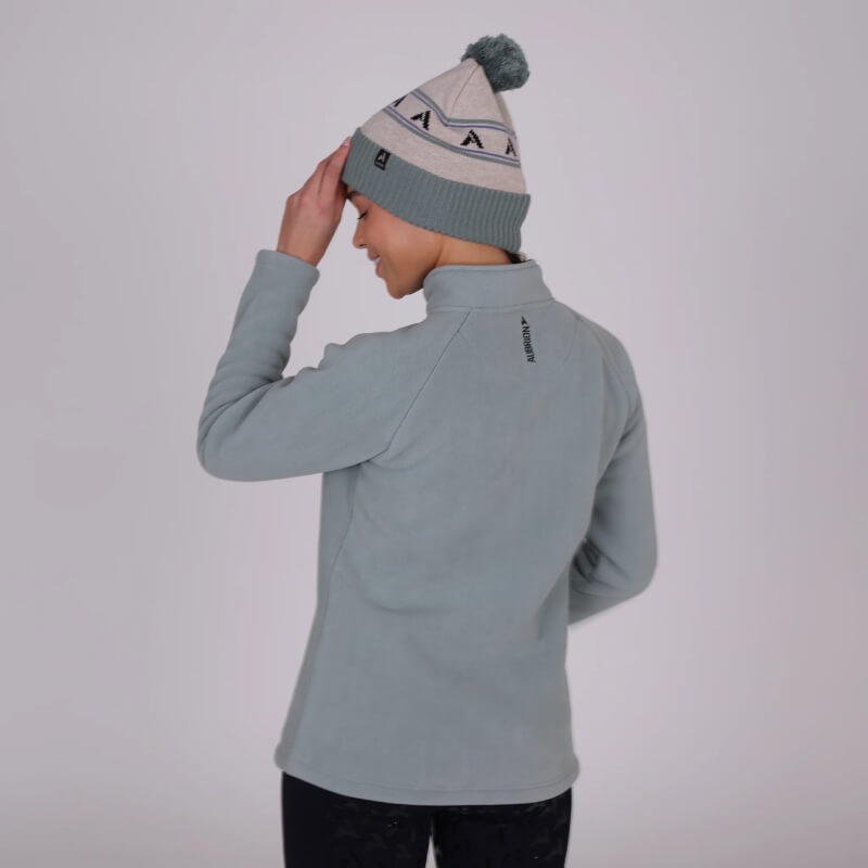 Person in a sage Aubrion React Half Zip Fleece and patterned beanie, seen from behind.
