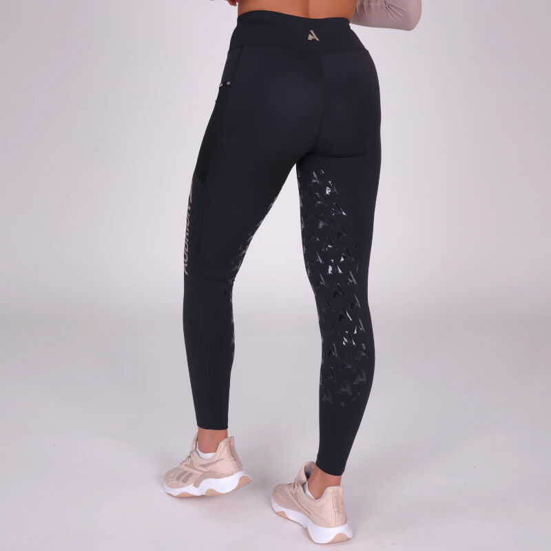 Person wearing Aubrion Non-Stop Riding Tights Shadow, back view, with beige sneakers.