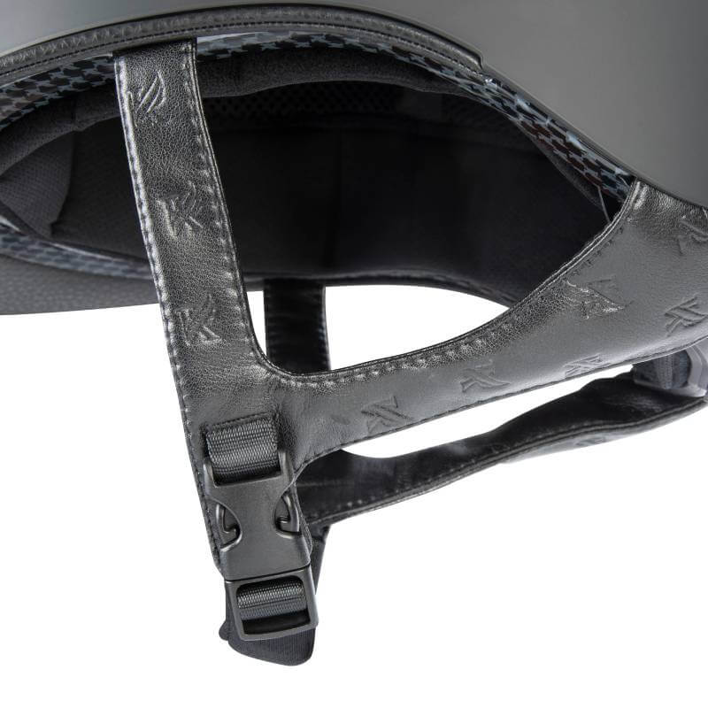 Close-up of a Shires Karben Amity LTHR Riding Hat Black strap with buckle and embossed LV logos.
