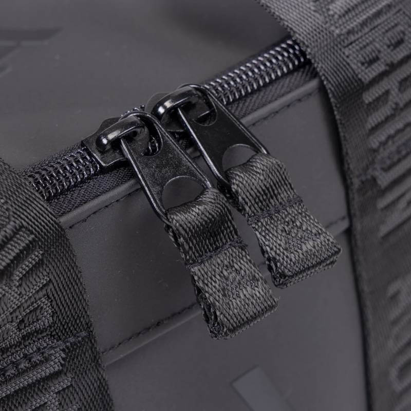 Close-up of two black zipper pulls on the Aubrion React Large Grooming Kit Bag Black.