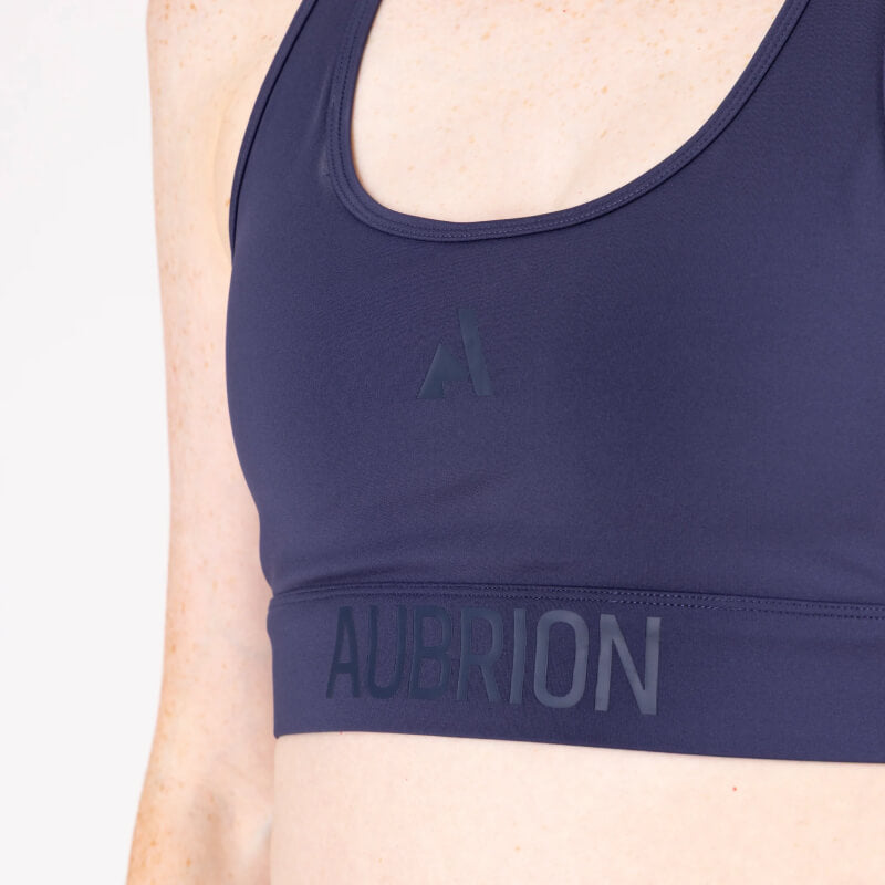 Wearing Aubrion React Power Sports Bra Midnight, AUBRION text visible on upper torso.
