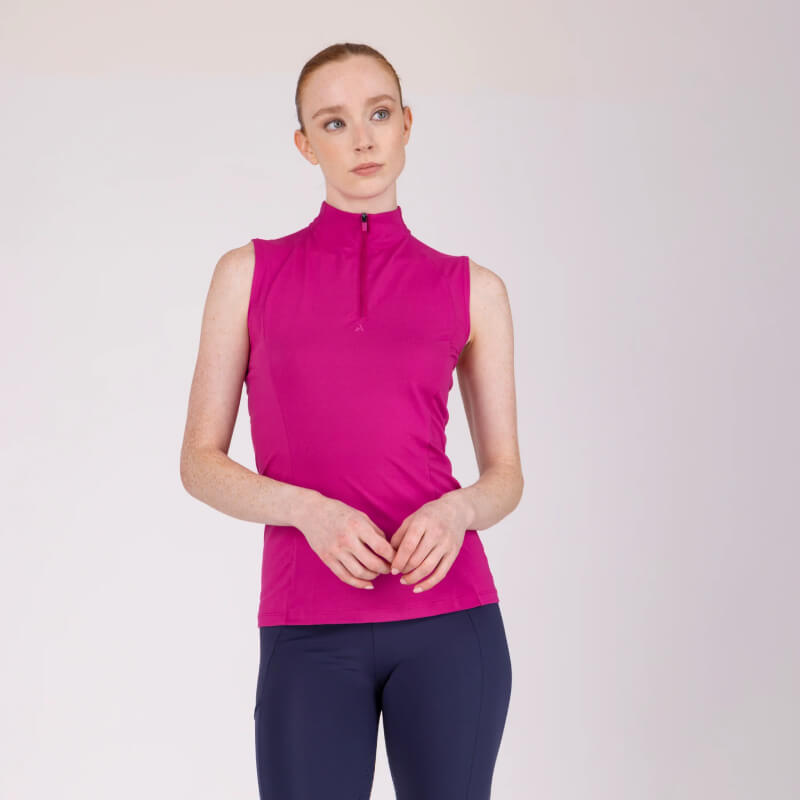 Woman in Aubrion React Sleeveless Baselayer Fuchsia and navy pants stands against plain background.
