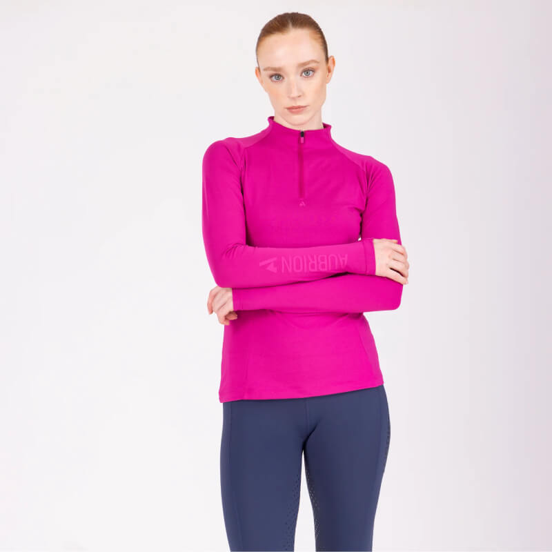 Woman in Aubrion React Long Sleeve Baselayer Fuchsia and navy leggings stands with arms crossed.