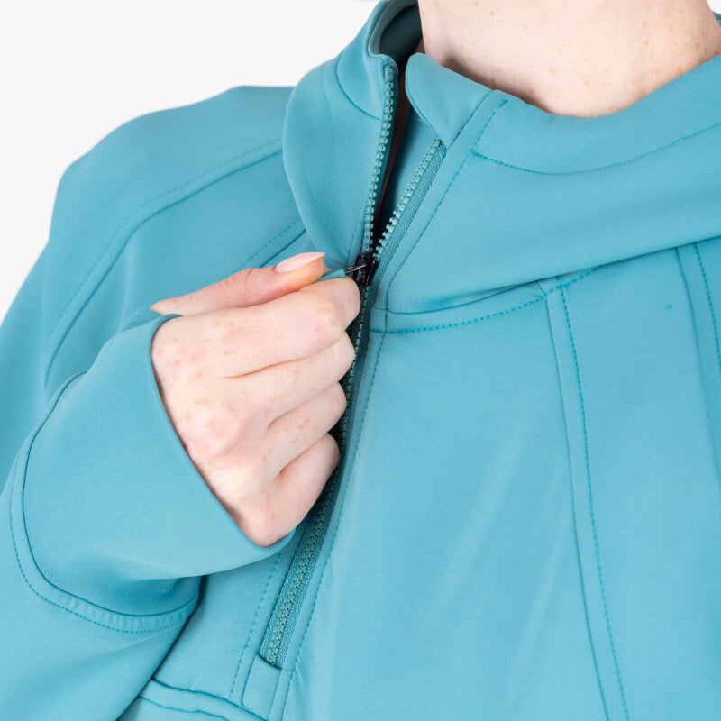 Woman wears Aubrion React Quarter Zip Hoodie Haze with navy bike shorts on a white background.