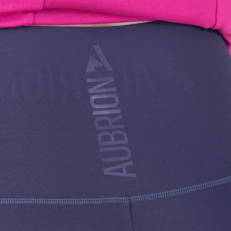 Close-up of Aubrion React Sculpt Riding Tights Midnight with AUBRION text and pink top garment.