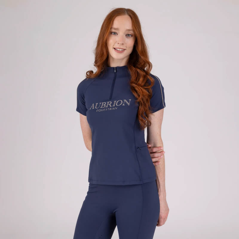 Woman with long red hair wears a navy Aubrion Short Sleeve Baselayer Midnight and matching pants.