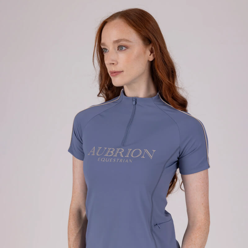 Woman with long red hair in Aubrion Storm baselayer, posing confidently in matching leggings.