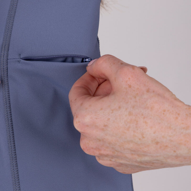 Hand opening a small zippered pocket on an Aubrion Short Sleeve Baselayer in Storm.