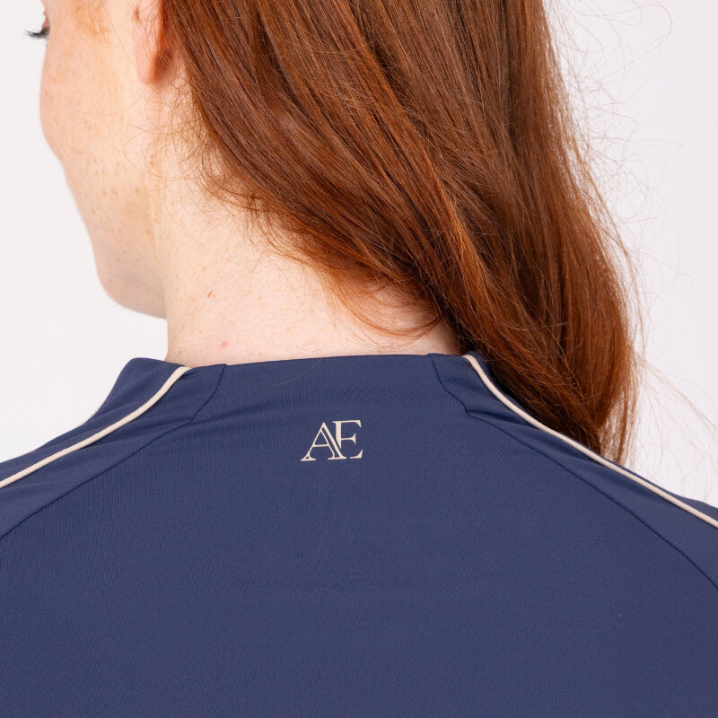 Red-haired rider in Aubrion Midnight baselayer with AE logo on back collar.