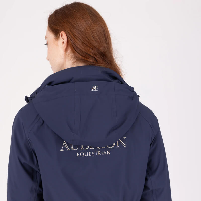 Person with long hair in an Aubrion Equestrian Lightweight Coat Midnight, seen from the back.