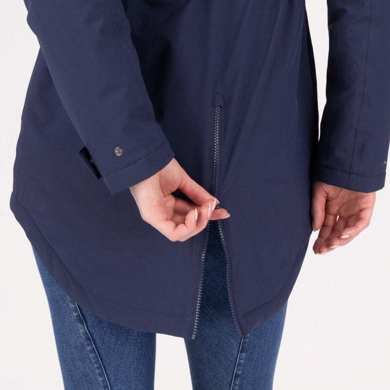 Person zipping Aubrion Equestrian Lightweight Coat Midnight, blue jeans visible waist down.