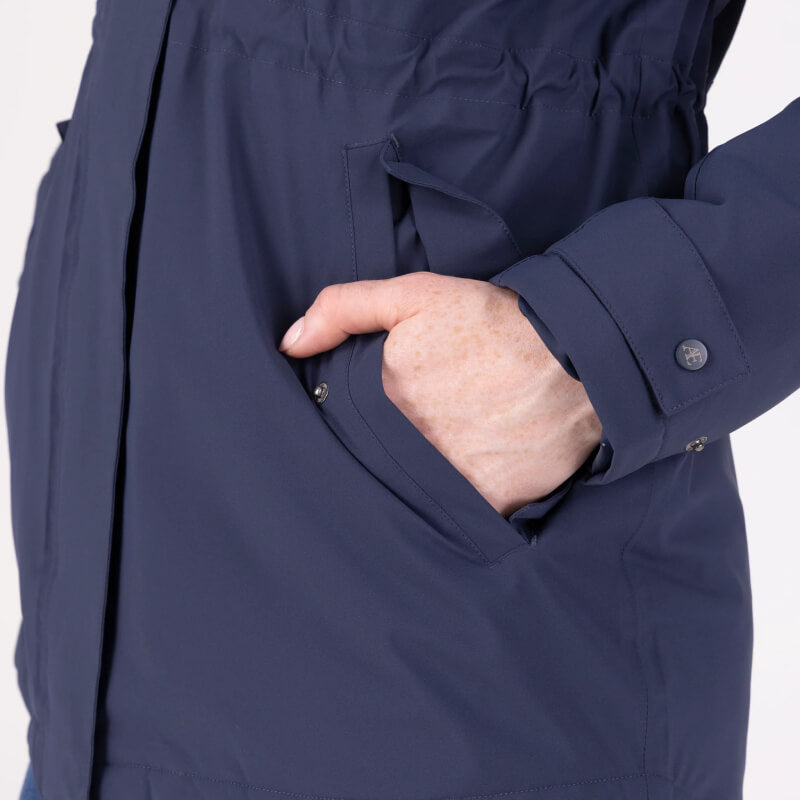 Someone puts their right hand in the pocket of an Aubrion Equestrian Lightweight Coat Midnight.