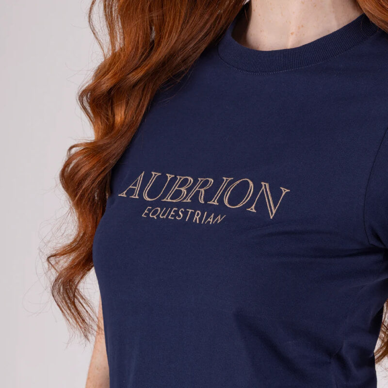 Woman in Aubrion Equestrian T-Shirt Midnight—perfect addition to your riding wardrobe.