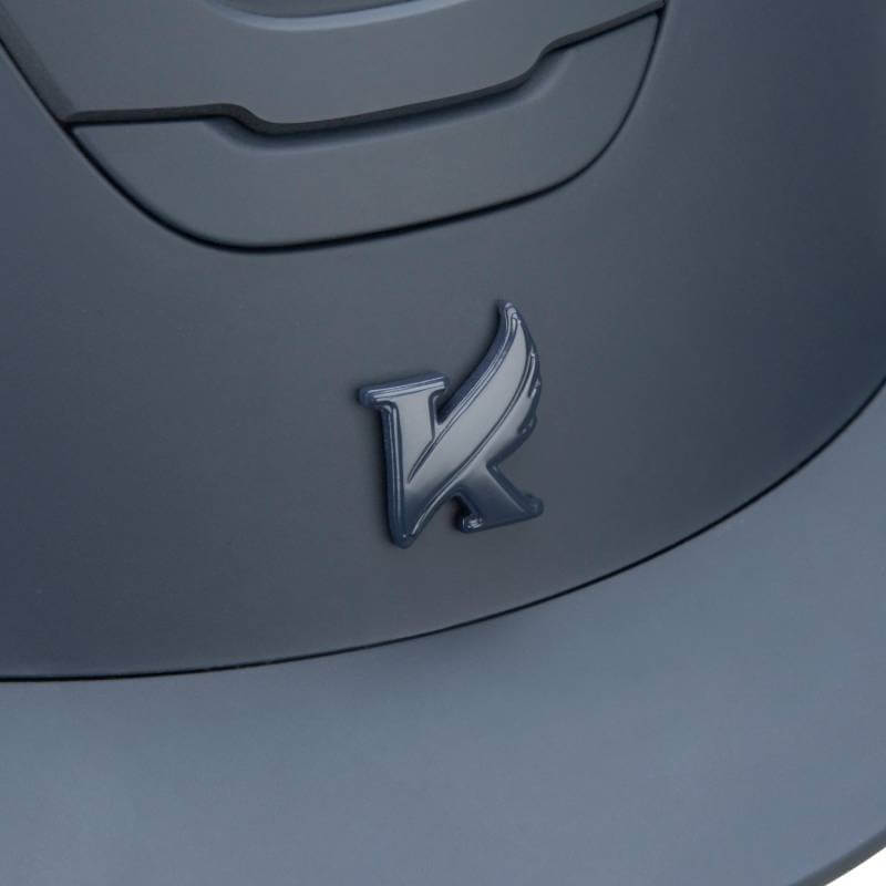 Close-up of the metallic K logo on the Shires Karben Amity SMRT Riding Hat in Navy.