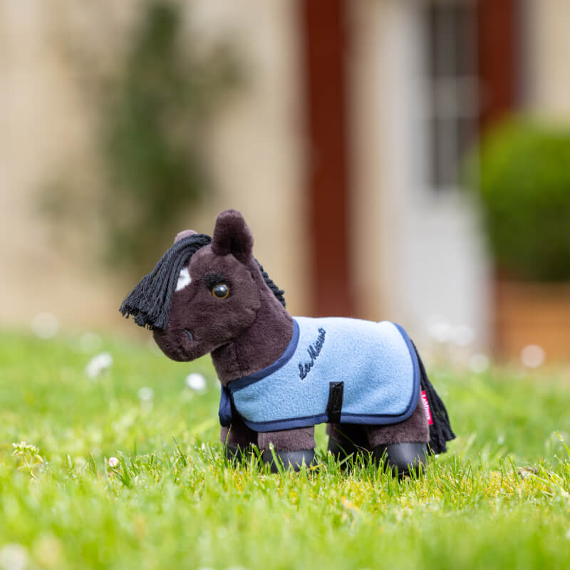 LeMieux Tiny Pony Freya by LeMieux with a blue coat stands on grass outdoors.