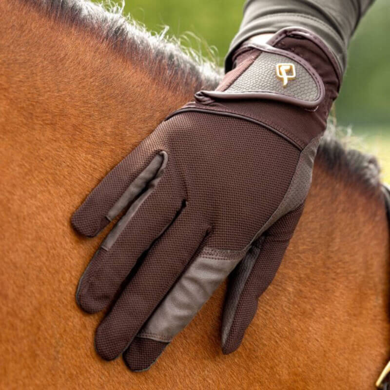 A gloved hand in LeMieux Pro Mesh Glove Brown gently rests on a horse’s coat.
