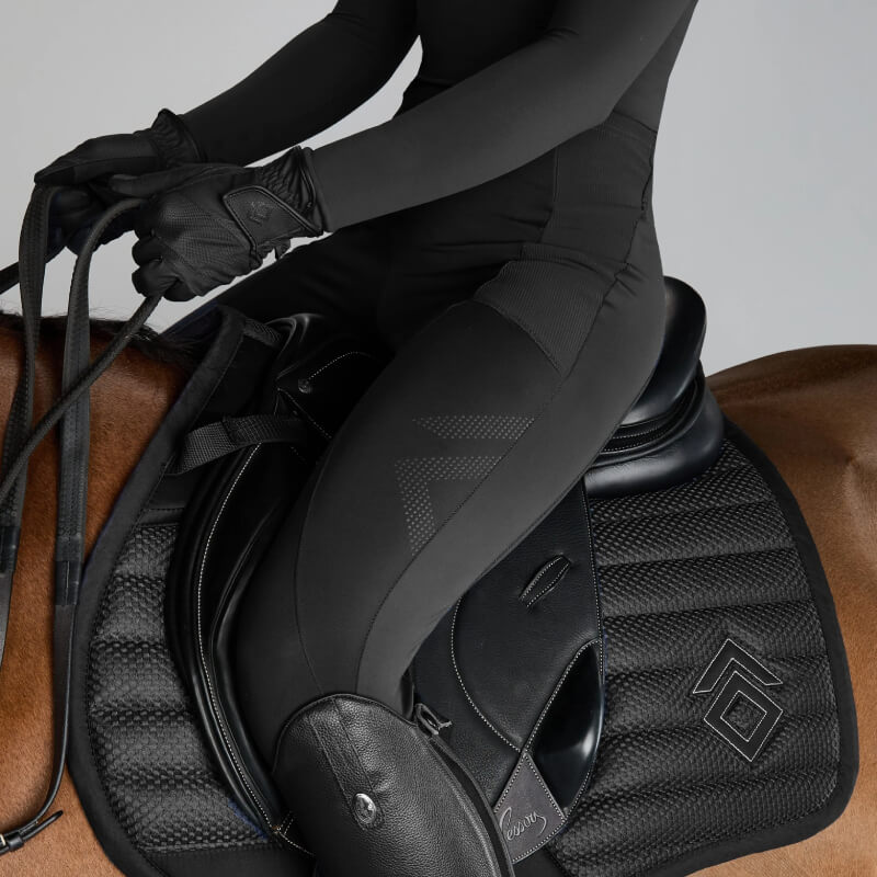 Rider in black Aztec Diamond Core Knee Grip Leggings sitting on brown horse, wearing gloves.