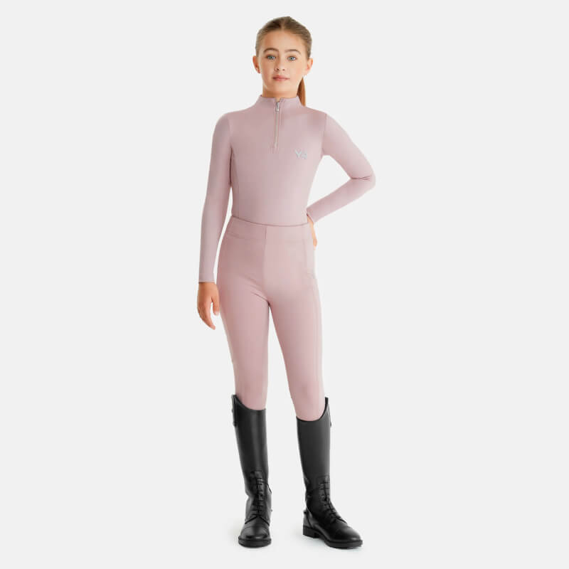 Young girl in Aztec Diamond YR Baselayer Pink and black boots poses confidently, hand on hip.