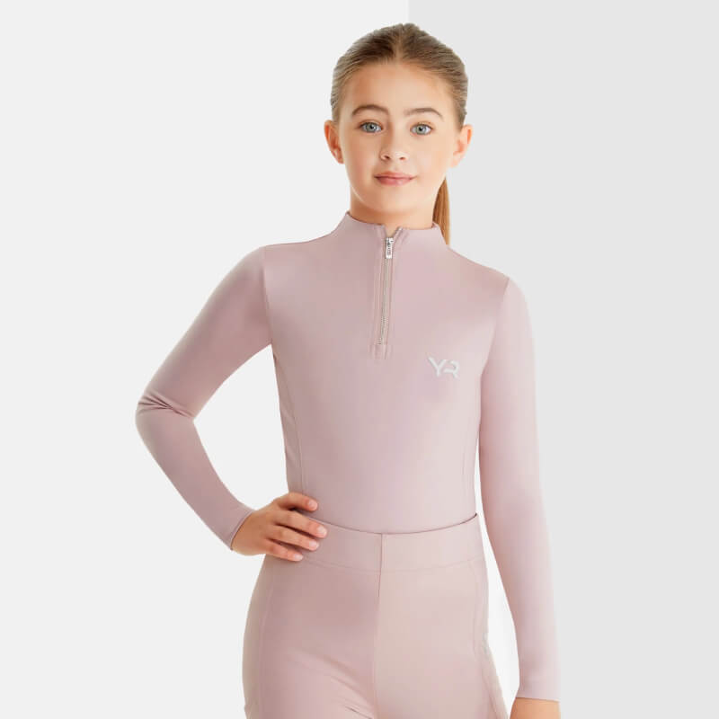 Girl in Aztec Diamond YR Baselayer Pink stands smiling, one hand on her hip.