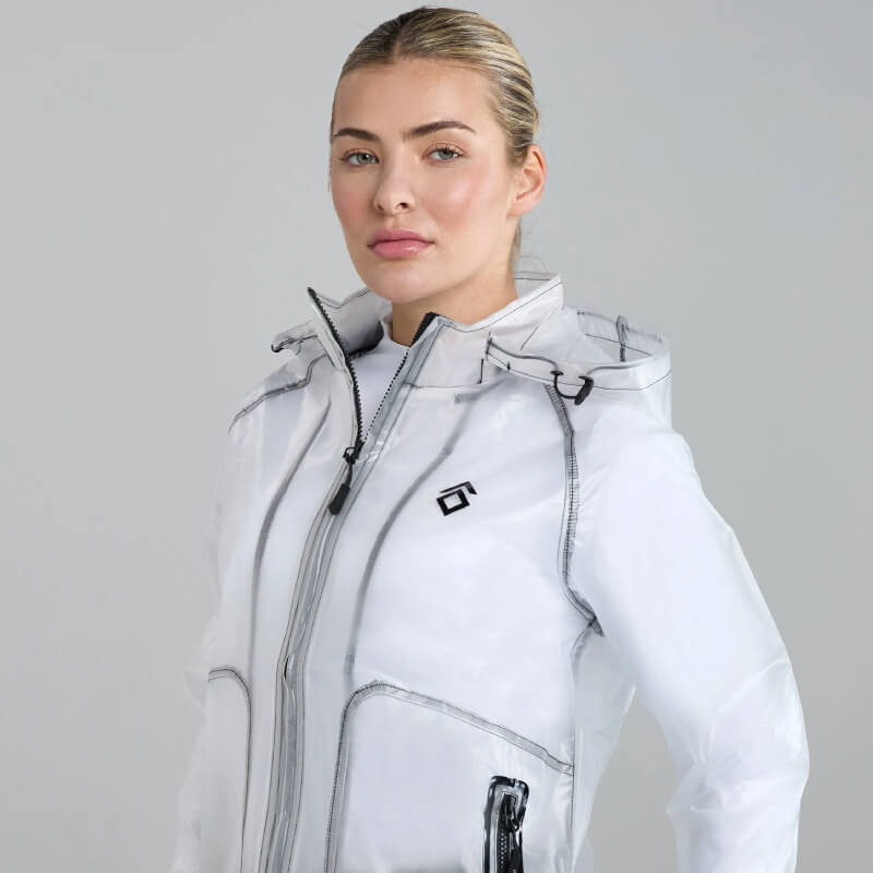 Person in Aztec Diamond Rain Jacket Clear stands against a gray background.