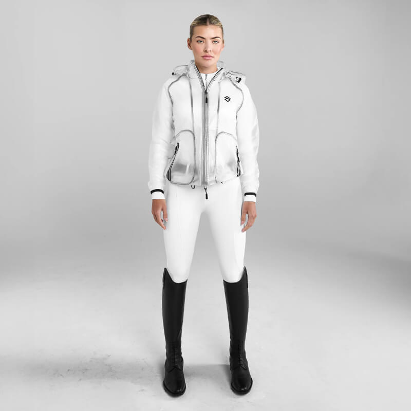 Person in Aztec Diamond Rain Jacket Clear stands against a gray background.