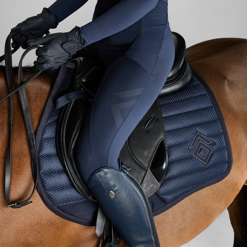Rider in navy on brown horse with Aztec Diamond Mesh Saddle Cloth Jump Cut Navy, holding reins.