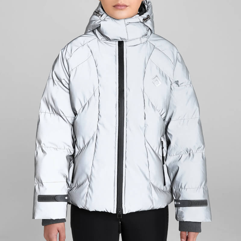 Woman in Aztec Diamond YR Puffer Coat Reflective stands against a plain gray background.
