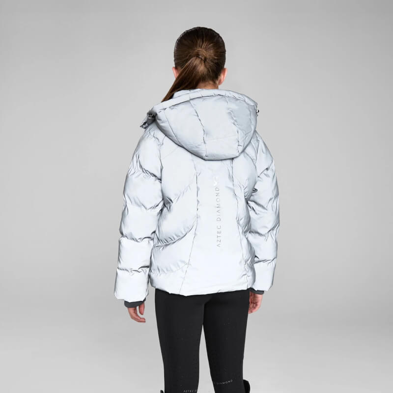 Model wears Aztec Diamond YR Puffer Coat Reflective, black pants, back view, gray background.