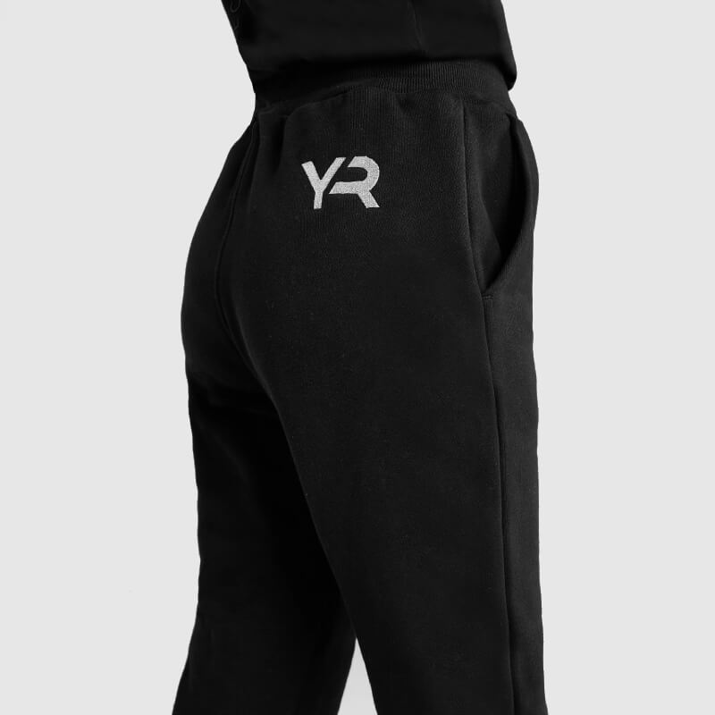 Person in Aztec Diamond YR Sweatpants Black/Pink, side view showing varsity logo by the pocket.