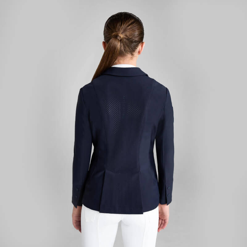 Woman in Aztec Diamond YR Competition Jacket Navy, viewed from behind on a gray background.