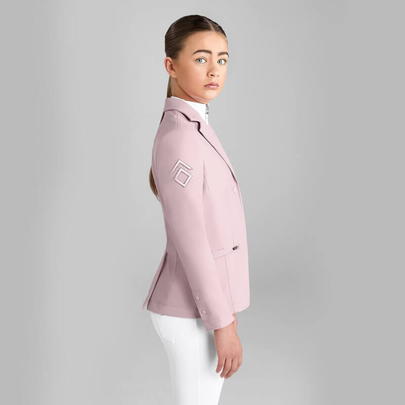 Woman in Aztec Diamond YR Competition Jacket Pink glances over shoulder against gray backdrop.