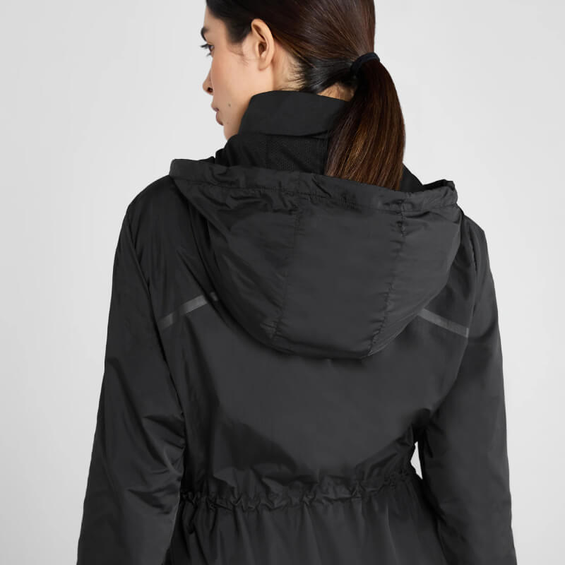 Brown-haired woman in ponytail wears Aztec Diamond Lightweight Rain Jacket Black, facing away.