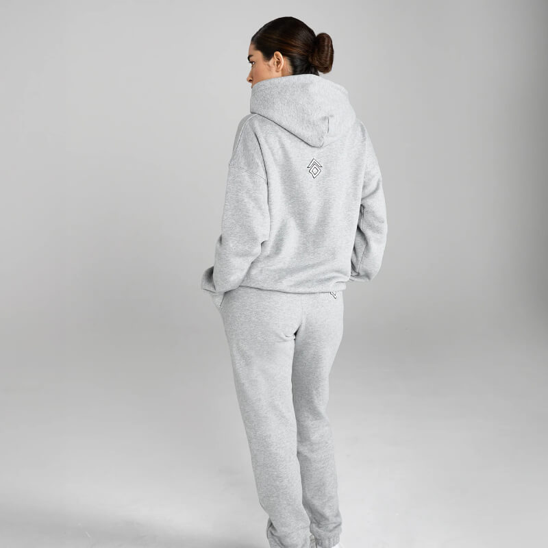 Woman wears Aztec Diamond EQ Club Pull on Hoodie Grey Marl, standing with back turned in studio.