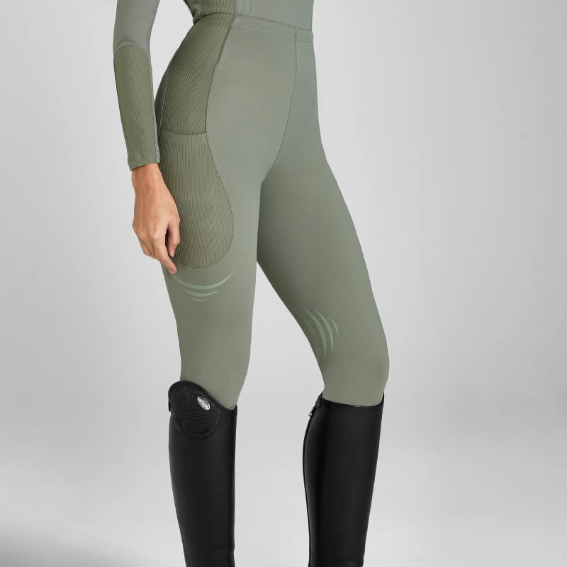Person in Aztec Diamond Define Leggings Knee Grip Sage and tall black riding boots, side view.