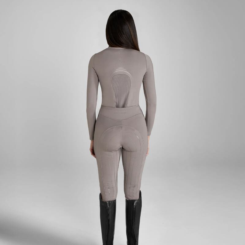 Woman in Aztec Diamond Define Baselayer Truffle and black boots, back to the camera.