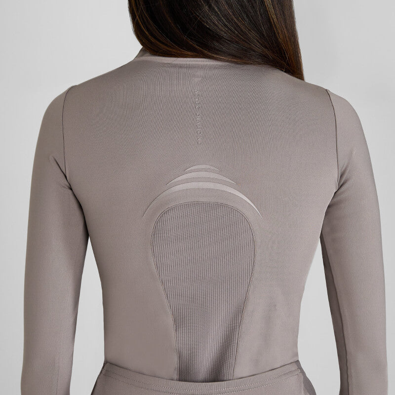 Back view of a person in an Aztec Diamond Define Baselayer Truffle top with mesh details.