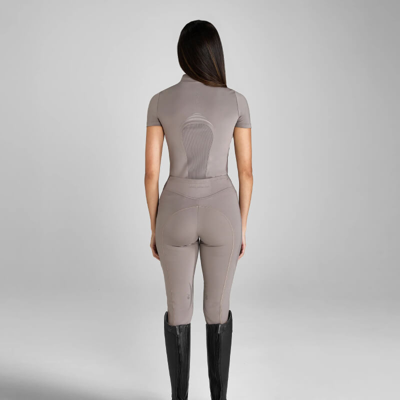 Woman in Aztec Diamond Define Leggings Knee Grip Truffle and black boots stands with her back turned.
