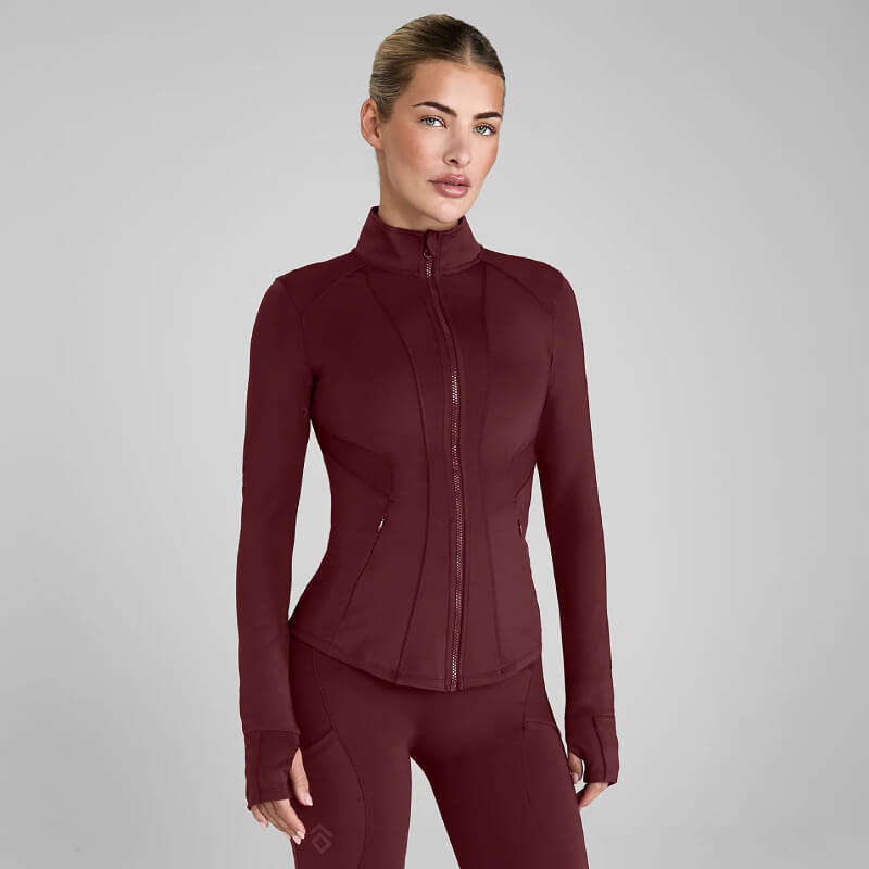 Woman in Aztec Diamond Core Fitted Jacket Cherry and matching recycled sports fabric leggings.