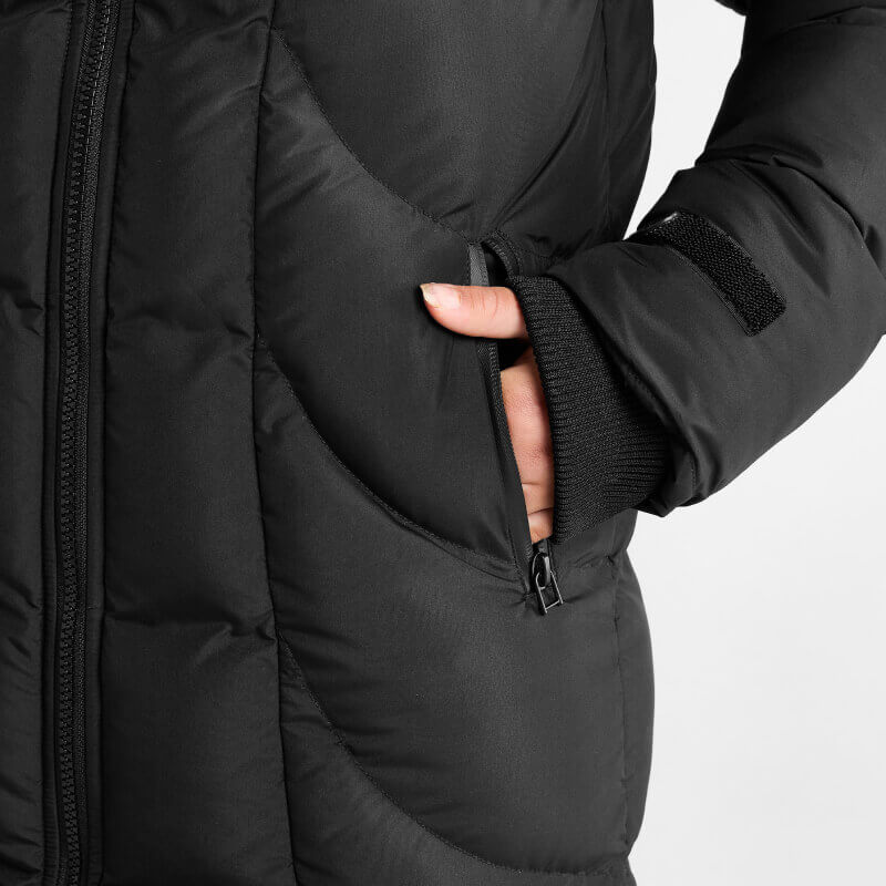 Wearing the Aztec Diamond Young Rider Long Puffer Jacket Black with hand in the zippered pocket.
