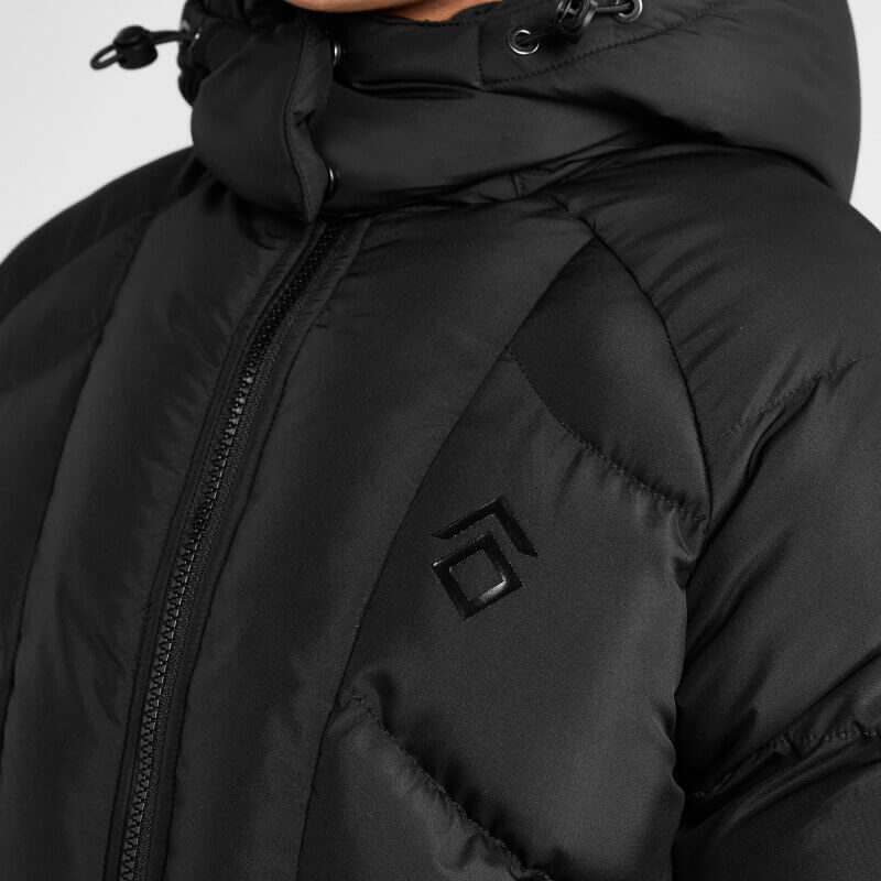 Close-up of Aztec Diamond Young Rider Long Puffer Jacket Black with zipper and chest logo.