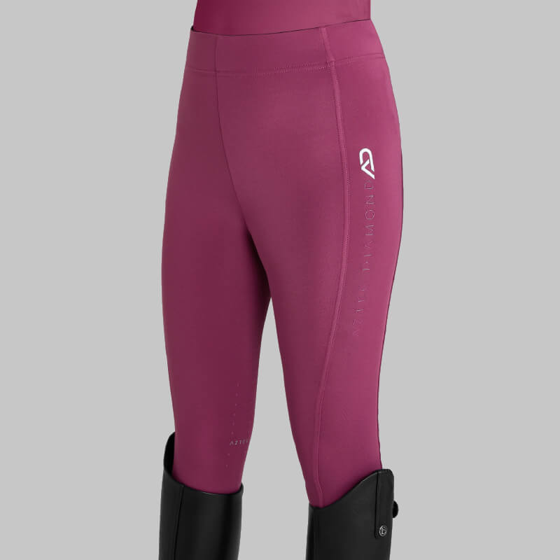 Wearing Aztec Diamond YR Full Seat Leggings Raspberry with black boots on a gray background.